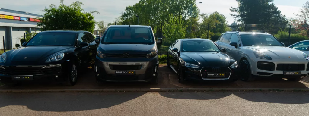 Quatre voitures de différentes marques et modèles stationnées en ligne, toutes affichant le logo RESTORFX sur leur pare-chocs avant