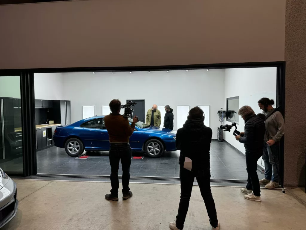 Tournage de l’émission Wheeler Dealers sur RMC Découverte dans un centre partenaire RestorFX, autour de la Peugeot 406 Coupé V6 avant sa restauration sans peinture.