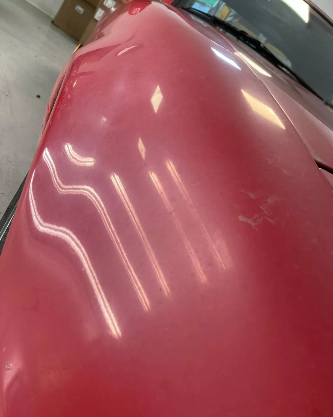 Peinture terne et oxydée sur une aile de voiture rouge, signe qu’il est temps de restaurer sa carrosserie avec une solution adaptée comme RestorFX